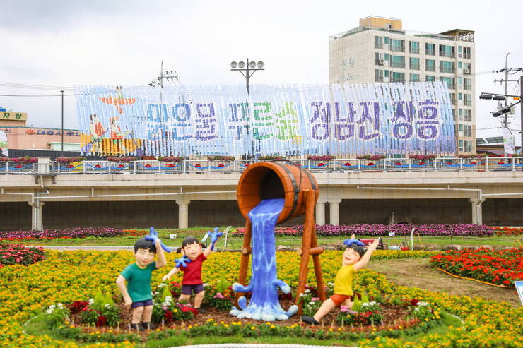 물축제 행사장 사진(조형물 뒤로 화단과 '맑은물 푸른숲 정남진 장흥' 홍보기가 보인다)