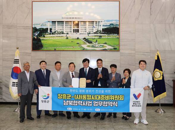 한반도 평화 분위기 조성을 위한 장흥군 -(사)통일시대준비위원회 남북협력사업 업무협약식 장흥군 사단법인 통일시대 준비위원회 현수막을들고 사진을 찍는 관계자들(크게보기)