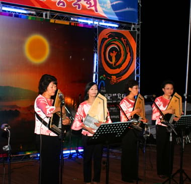 무대위에 서서 악기를 연주하는 네명의 여인