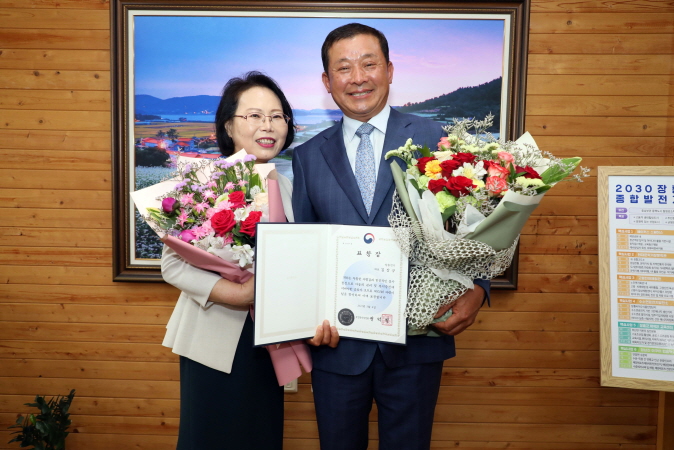 김장규 장흥전기 대표가 표창장과 꽃다발을 들고 기념촬영을 하고 있다.