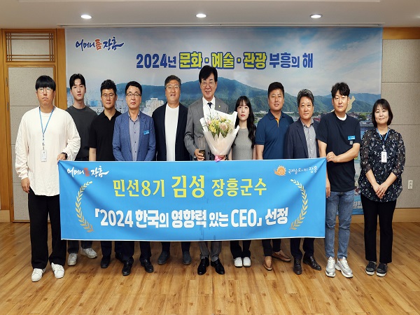 어머니품장흥 민성8기 김성 장흥군수 2024한국의 영향력있는 CEO선정 현수막을 들고 관계자들과 함께 사진을 찍는 장흥군수 